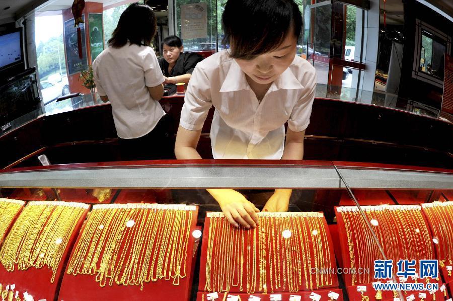 9月26日，浙江義烏一金店工作人員在整理上柜銷(xiāo)售的黃金飾品。隨著國(guó)際黃金市場(chǎng)風(fēng)云突變，國(guó)內(nèi)金價(jià)26日繼續(xù)大跌。與此同時(shí)，曾經(jīng)高高在上的鉑金價(jià)格也大幅下調(diào)，出現(xiàn)了黃金價(jià)格全面高于鉑金價(jià)格的罕見(jiàn)倒掛現(xiàn)象。26日，上海黃金交易所黃金Au99.95合約收盤(pán)價(jià)為每克327.95元，而鉑金Pt99.95合約收盤(pán)價(jià)僅為每克326.08元。