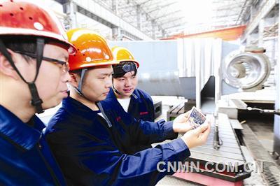 中信重工十九大代表劉新安的徒弟在工位上通過手機收看十九大開幕式實況。