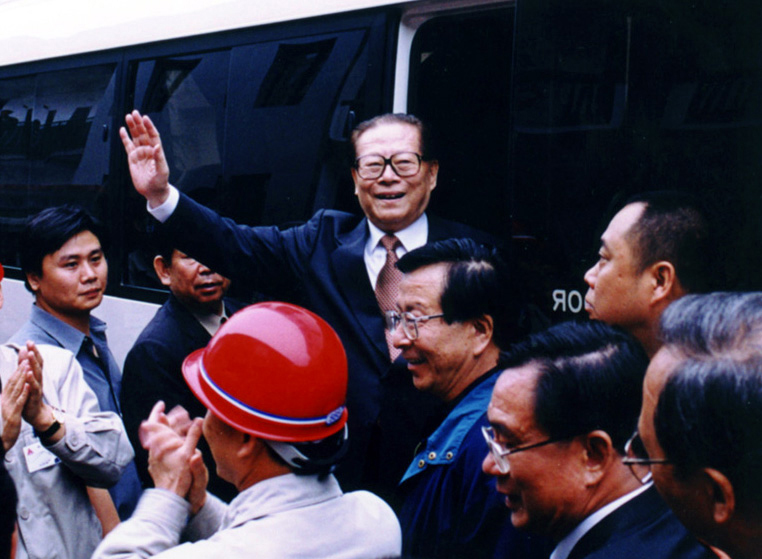 “同志們好！”“大家好！”邁出車門的江澤民向激動沸騰的西南鋁職工微笑地點頭，爽朗地問好，親切地揮手致意。（李影攝）