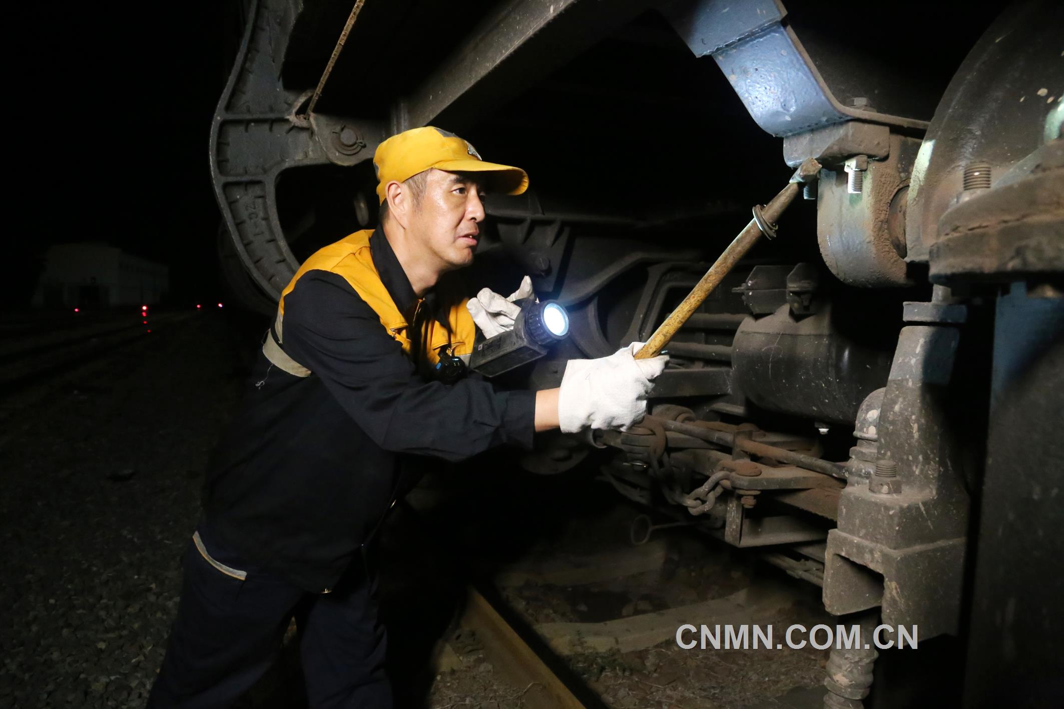 焦建智正在對待發(fā)礦石專列進行發(fā)車前的技術檢查。