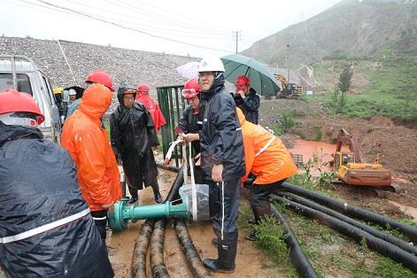 圖一為中州鋁業(yè)保障中心員工冒雨在現(xiàn)場(chǎng)搬運(yùn)潛水泵設(shè)備，以應(yīng)對(duì)未來幾天更加嚴(yán)峻的汛情。